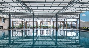 An indoor swimming pool with a clear view of the cityscape through large windows. - Wyndham Garden Kunming High Tech Zone (Kunming)