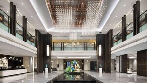 A spacious lobby with a reflective floor, a reception desk, and a central decorative water feature. - Wyndham Garden Kunming High Tech Zone (Kunming)