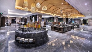 A spacious lobby with a marble floor, a central bar area with various items, and multiple hanging light fixtures. - Wyndham Garden Kunming High Tech Zone (Kunming)