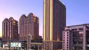 A high-rise hotel with multiple floors, a prominent sign at the top, and a well-lit facade. - Wyndham Garden Kunming High Tech Zone (Kunming)