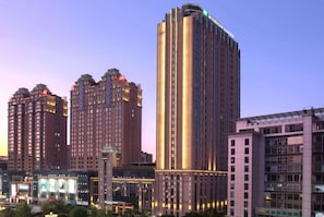 Ein Hochhaus-Hotel mit mehreren Etagen, einer auffälligen Beschilderung im oberen Bereich und einer gut beleuchteten Fassade.