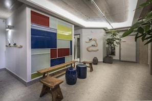 A hallway with a bench, stools, and a potted plant. - Cretan Blue Beach Hotel (Hersonissos)