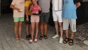 Un grupo de personas en una habitación con una mesa de recepción y un reloj en la pared.