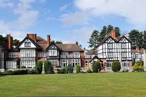 Un edificio de estilo Tudor tradicional, con varios tejados a dos aguas y ventanas enmarcadas en blanco.