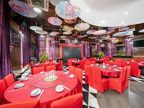 A restaurant with round tables, red chairs, and a black and white checkered floor. - The BLD International Hotel (Dongguan)