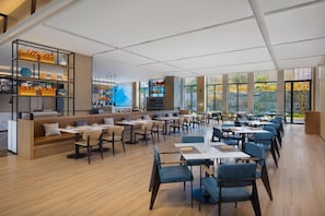 A modern restaurant with a long dining area, booths, and a bar area with shelves. - Fairfield by Marriott Bijie (Bijie)