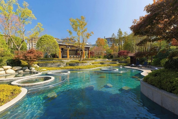 A swimming pool with a circular design, surrounded by landscaped gardens and a traditional building. - Fairfield by Marriott Bijie (Bijie)
