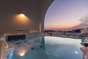 Un jacuzzi con vistas despejadas a la puesta de sol y montañas al fondo.