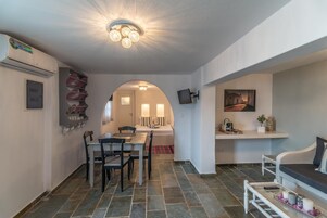 A modern interior with a dining area, a living space, and a hallway leading to a bedroom.