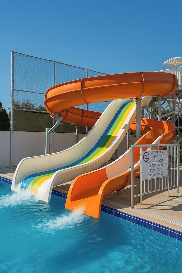Ein Wasserpark mit mehreren Rutschen, einem Pool und einem umzäunten Bereich.