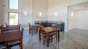 A spacious dining area with a kitchen in the background. - OYO Hotel Adairsville Calhoun South I-75 (Adairsville)