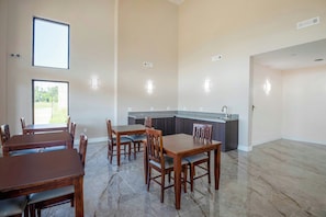 A spacious dining area with a kitchen in the background. - OYO Hotel Adairsville Calhoun South I-75 (Adairsville)