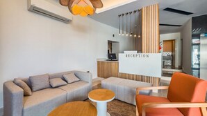 A reception area with a sofa, a round table, and a reception desk. - Dedeoglu Hotel (Fethiye)