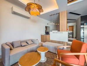 A reception area with a sofa, a round table, and a reception desk. - Dedeoglu Hotel (Fethiye)