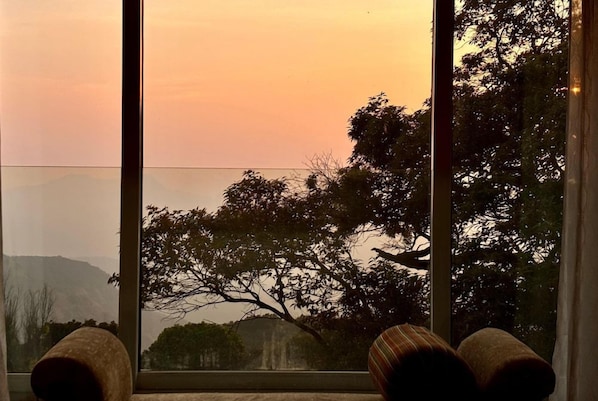 A room with a large window offering a view of trees and a distant landscape. - Fountain Mahabaleshwar Ihcl Seleqtions (Mahabaleshwar)