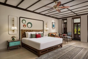 A bedroom with a large bed, bedside tables, a desk, and a ceiling fan. - Fountain Mahabaleshwar Ihcl Seleqtions (Mahabaleshwar)
