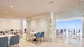 A modern dining area with marble walls and a high ceiling. - Nur Al Naseem by Makarem (Makkah)