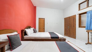 Quarto com duas camas, um guarda-roupa de madeira, uma porta e uma janela com cortinas.