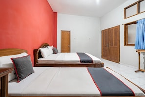 Un dormitorio con dos camas, un armario de madera, una puerta y una ventana con cortinas.