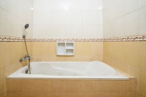 Un baño de hotel estándar con bañera, ducha e inodoro.