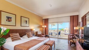 A hotel room with a bed, a desk, a TV, and a balcony with a view of the sea. - Cleopatra Luxury Resort Makadi Bay-adults Only 16 (Makadi Bay)