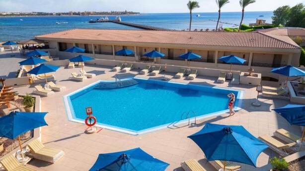 A hotel pool area with a clear view of the sea, sun loungers, and umbrellas. - Cleopatra Luxury Resort Makadi Bay-adults Only 16 (Makadi Bay)