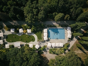 An aerial view of a resort with a swimming pool, sun umbrellas, and a landscaped garden. - Roncolo 1888 (Quattro Castella)