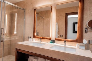 A modern bathroom with a glass shower enclosure, a double sink vanity, and a large mirror. - Hotel Via Veneto (Rome)
