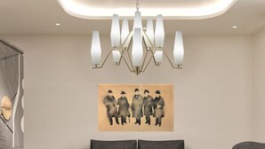 A modern living room with a grey sofa, a round coffee table, and a chandelier. - Hotel Via Veneto (Rome)