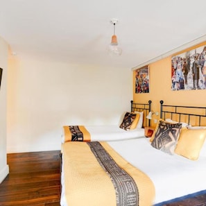 Una camera d'albergo con un letto, un comodino, una lampada e un quadro appeso al muro.
