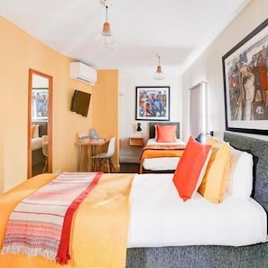 A hotel room with a bed, a desk, a chair, a mirror, and a framed picture on the wall. - Dancenter Southwark Near London Bridge (London)