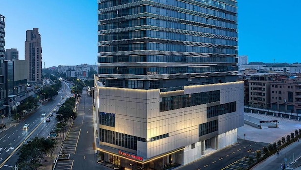 Ein mehrstöckiges Hotel mit moderner Glasfassade an einer Stadtkreuzung.