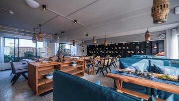 A modern interior with wooden furniture, hanging lights, and a large bookshelf.
