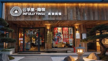 Un edificio con fachada de madera y letreros que indican 'INFULLY YINSU'.