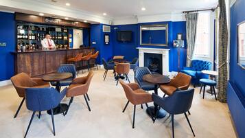A bar area with a bartender, a fireplace, and seating arrangements.