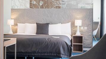 A modern bedroom with a large bed, bedside lamps, a chair, and a decorative wall panel.