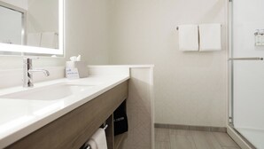 A modern bathroom with a large mirror, a sink, and a shower area. - Holiday Inn Express & Suites Diamond (Diamond)