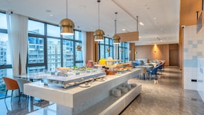 A modern hotel dining area with a buffet setup, large windows, and contemporary lighting fixtures. - Holiday Inn Express Nanning Convention and Exhibition (Nanning)