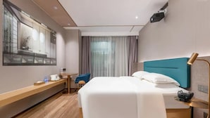 A hotel room with a bed, a desk, a chair, a TV screen, and a window with curtains. - Cheermay Hotels (Guangzhou)