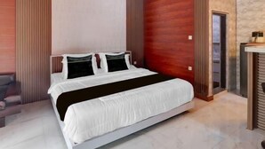 Quarto moderno com uma cama grande, teto de madeira e parede de pedra.