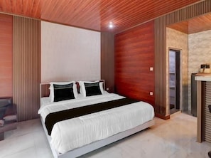 Ein modernes Schlafzimmer mit einem großen Bett, einer Holzbalkendecke und einer Steinwand.