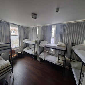 A dormitory room with bunk beds, a small table, and a chair. - Amigo Budget Hotel (Amsterdam)