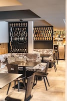 Un interior moderno con una zona de bar, asientos y un separador decorativo.
