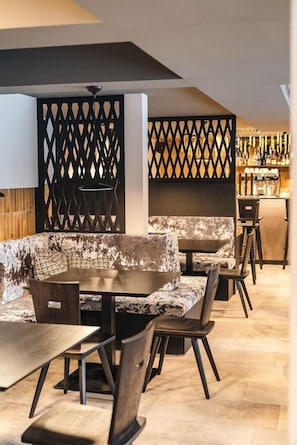 Ein modernes Interieur mit Barbereich, Sitzgelegenheiten und einer dekorativen Trennwand.