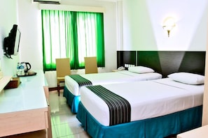 Habitación de hotel con dos camas, un escritorio, una silla, un televisor y una ventana con cortinas.