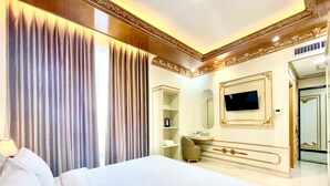 Ein Hotelzimmer mit einem großen Bett, einem Fernseher, einem Spiegel und einem Kleiderschrank.