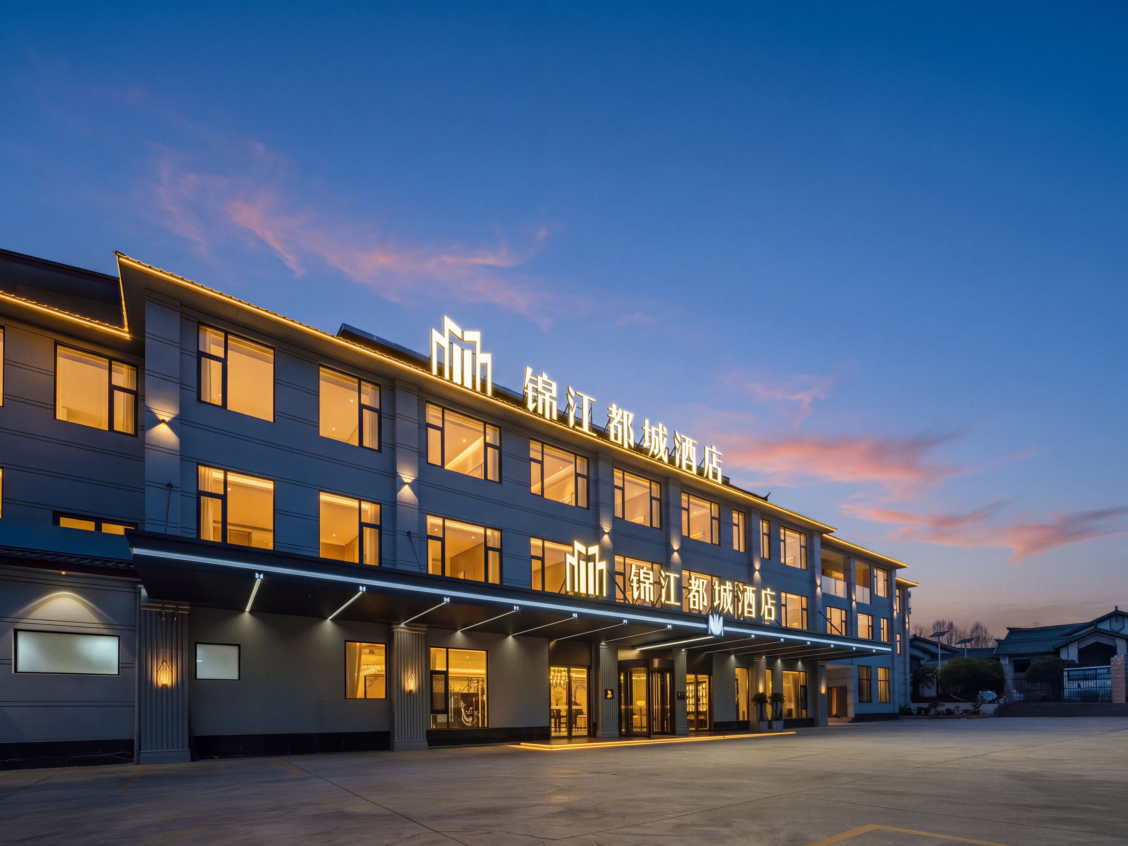 A hotel with a modern facade, multiple windows, and illuminated signage.