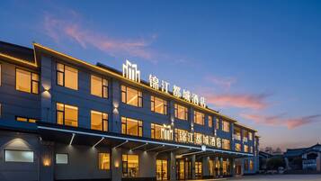 A hotel with a modern facade, multiple windows, and illuminated signage.