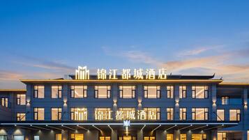 A hotel with a modern facade, illuminated signage, and a spacious entrance area.