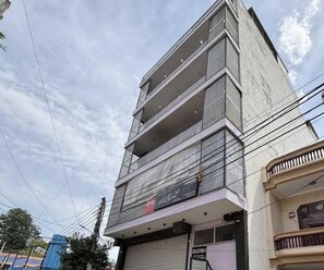 A multi-story building with a balcony on the ground floor. - Deluxe Room Collection O Sadar Bazaar (Gurugram)